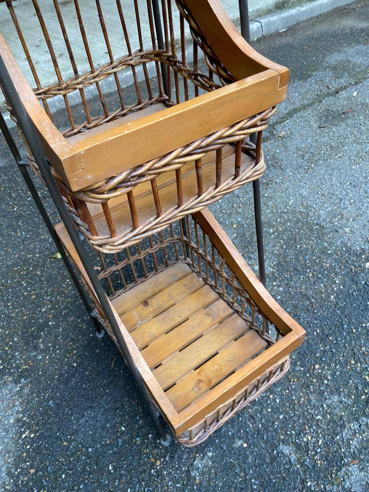 Woven rattan and steel display shelf in the shape of a staircase.