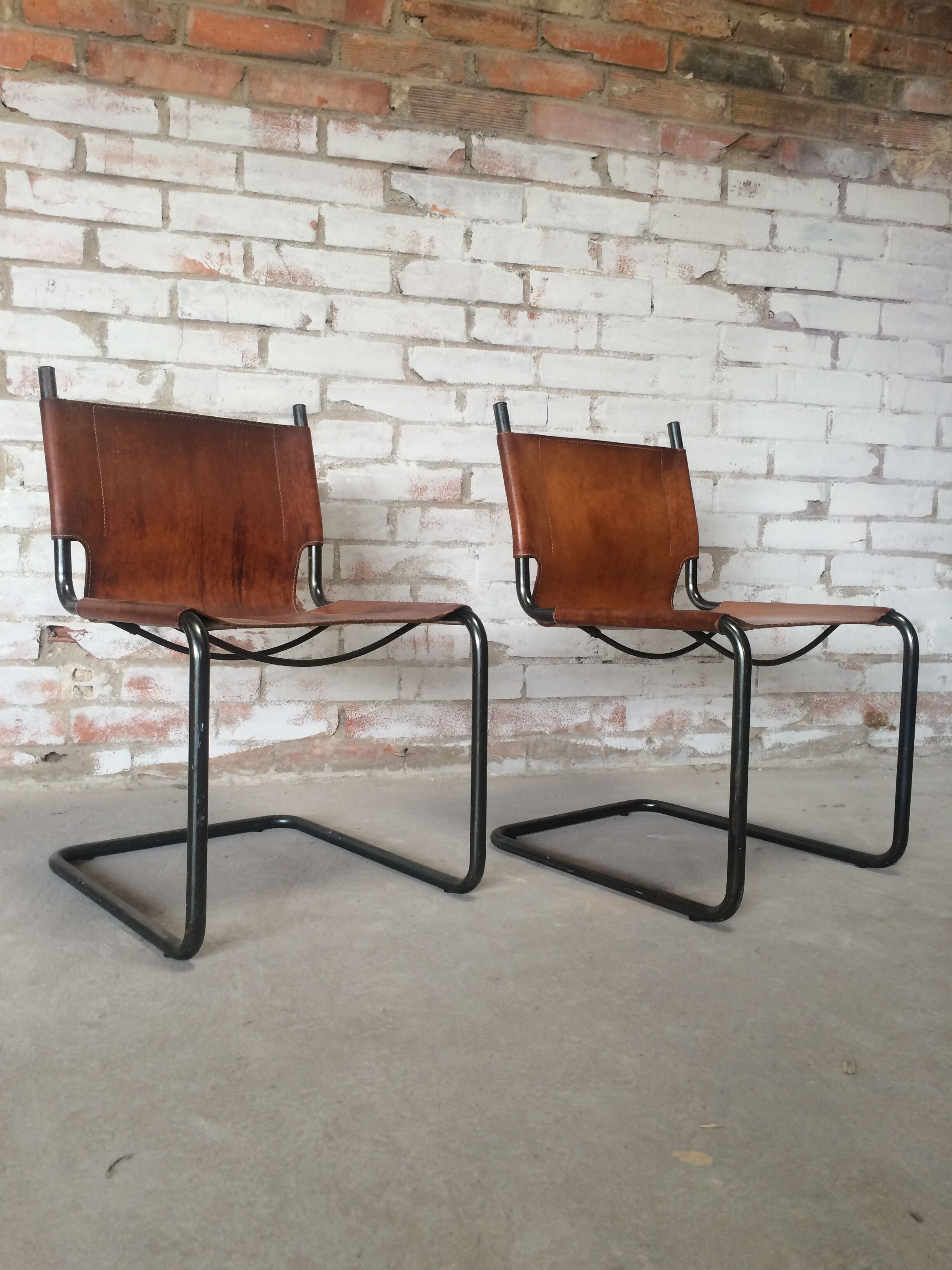 pair of tubular chairs in tawny leather