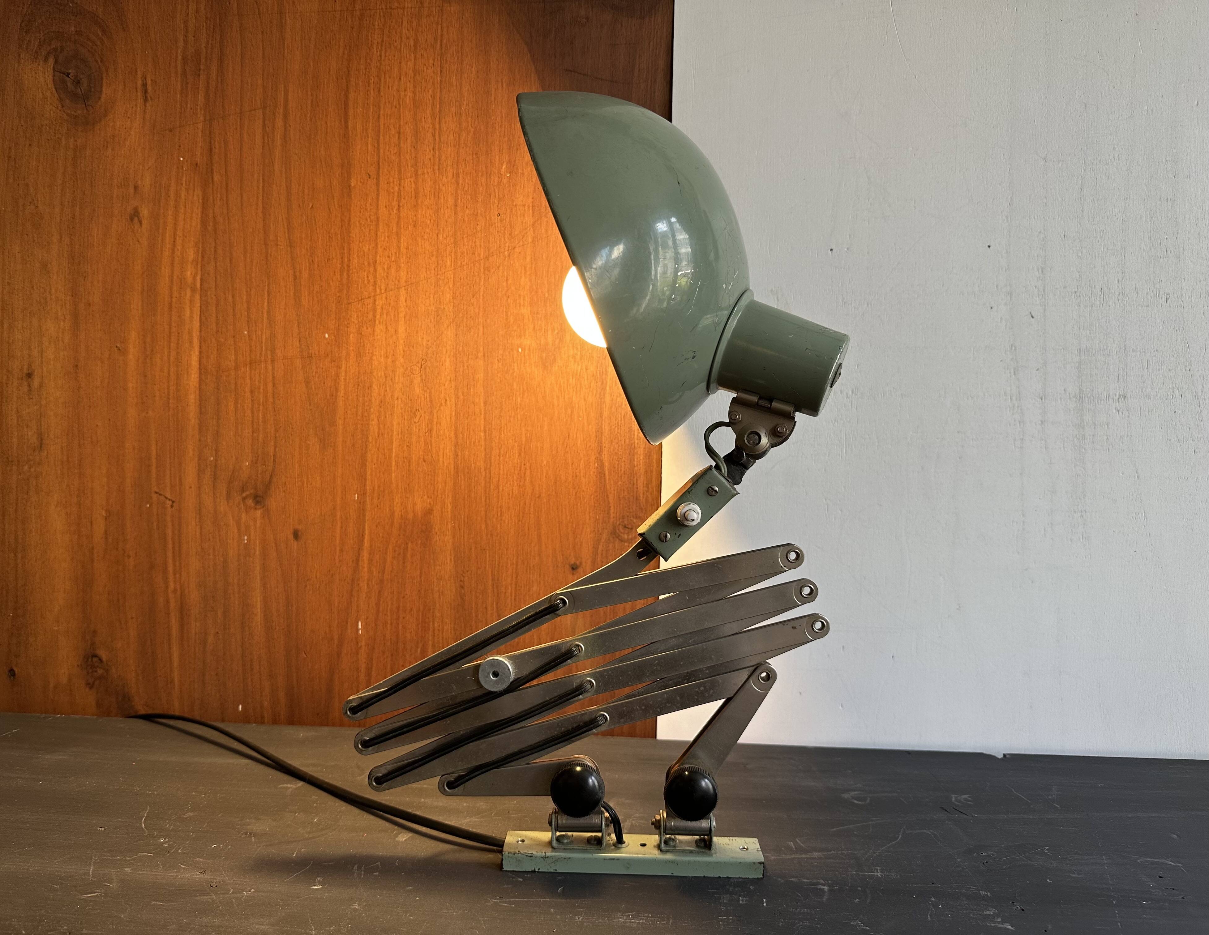 Old extendable accordion lamp in celadon green, workshop spirit.