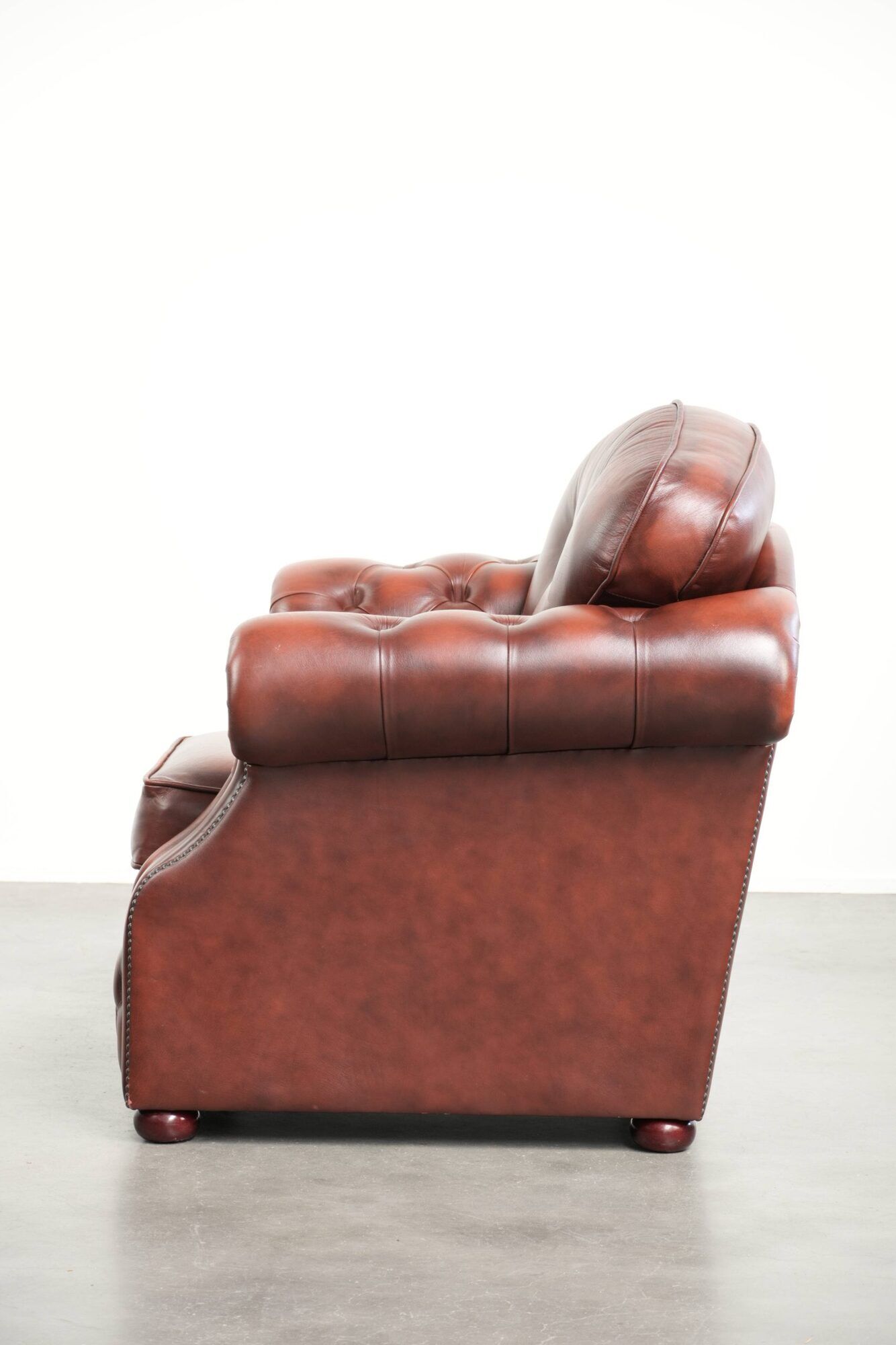 Cowhide chesterfield armchair in a warm brown colour with decorative nails