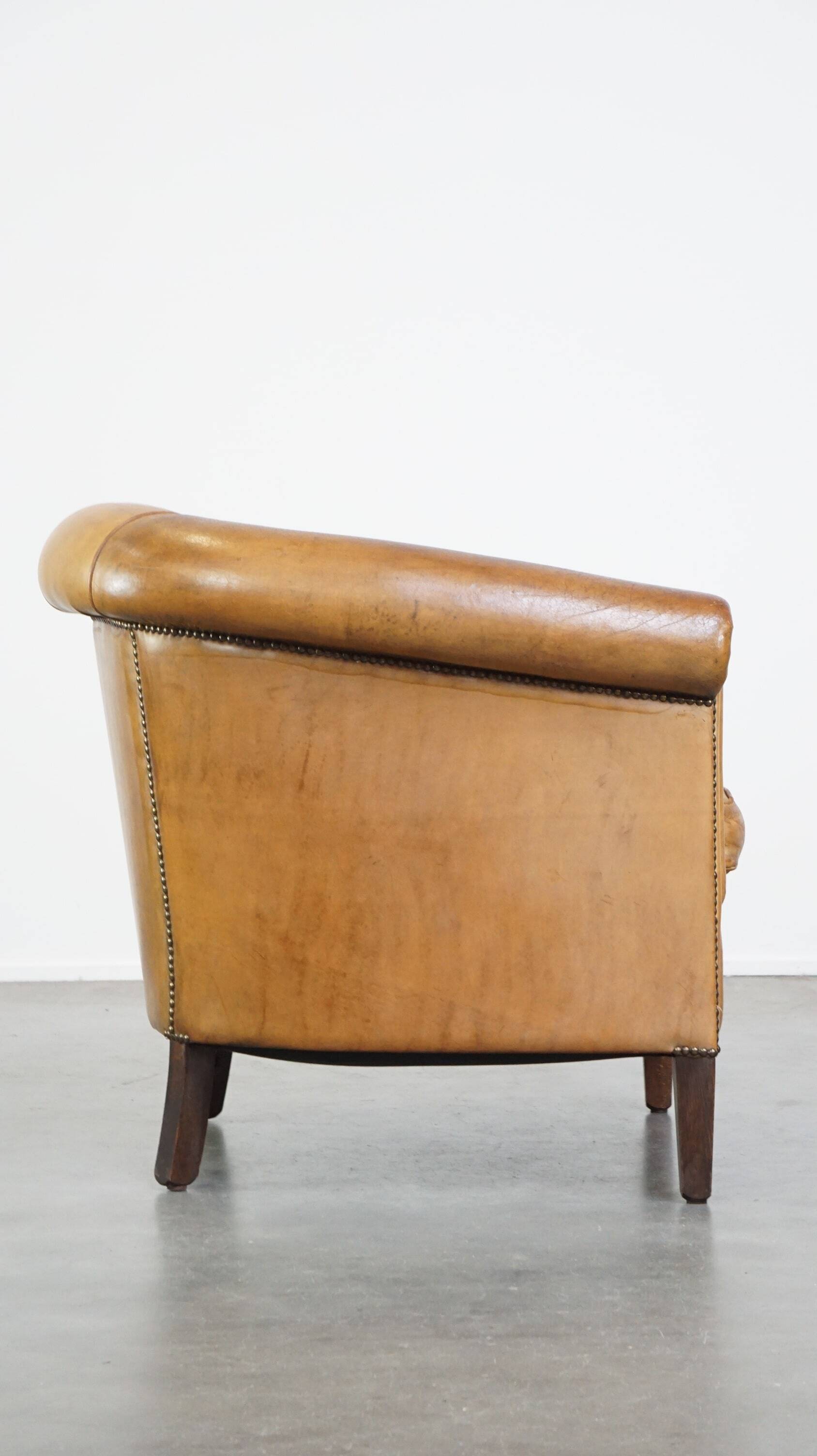 Comfortable, cozy, warm colored sheepskin club chair finished with decorative nails