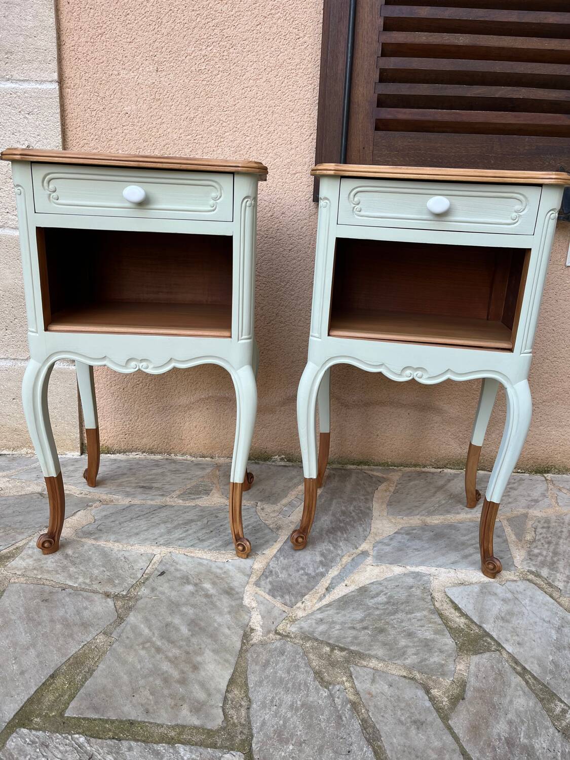 Renovated bedside tables in laurel green and light wood.