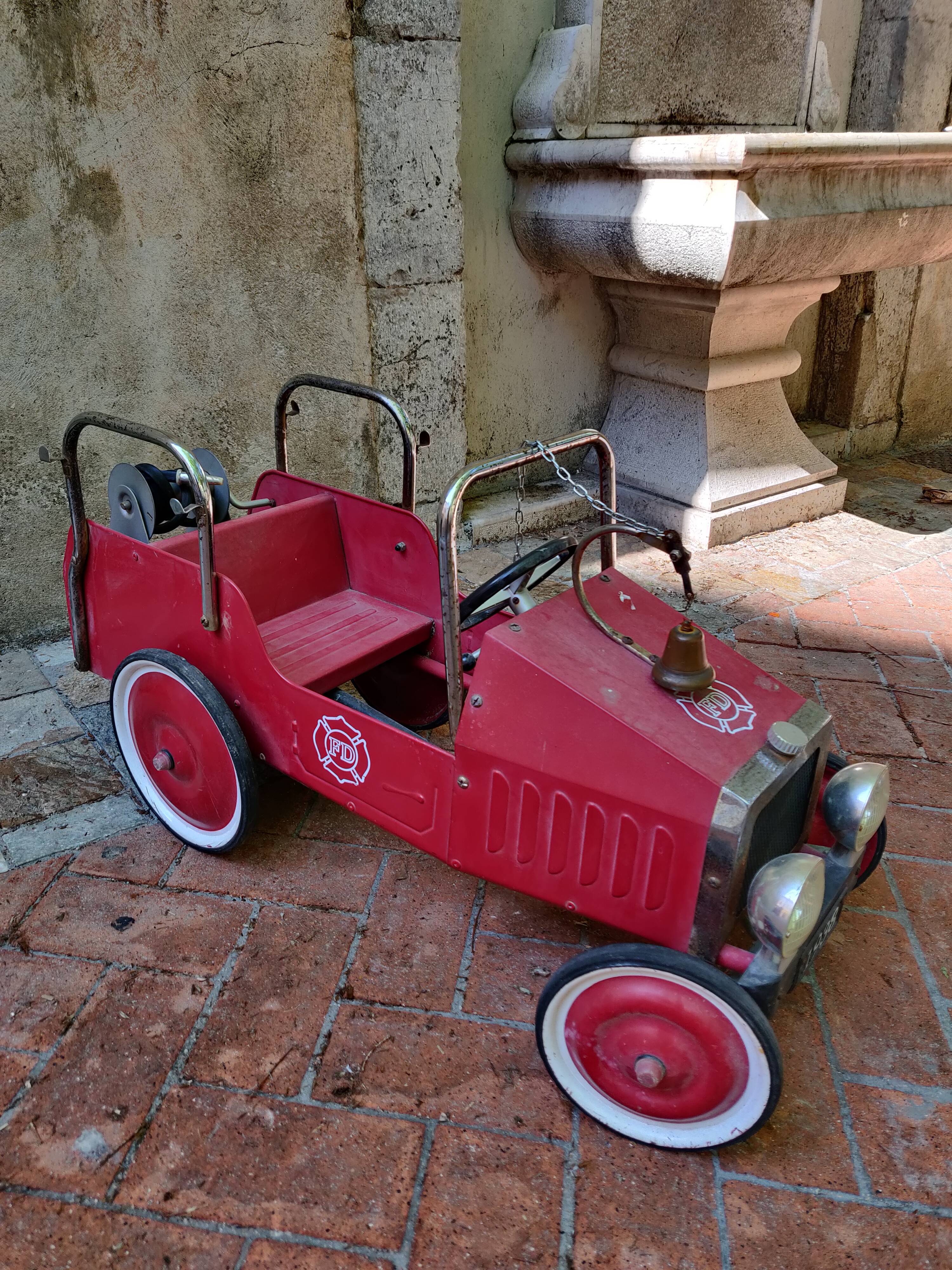 Old pedal car in tole fire truck