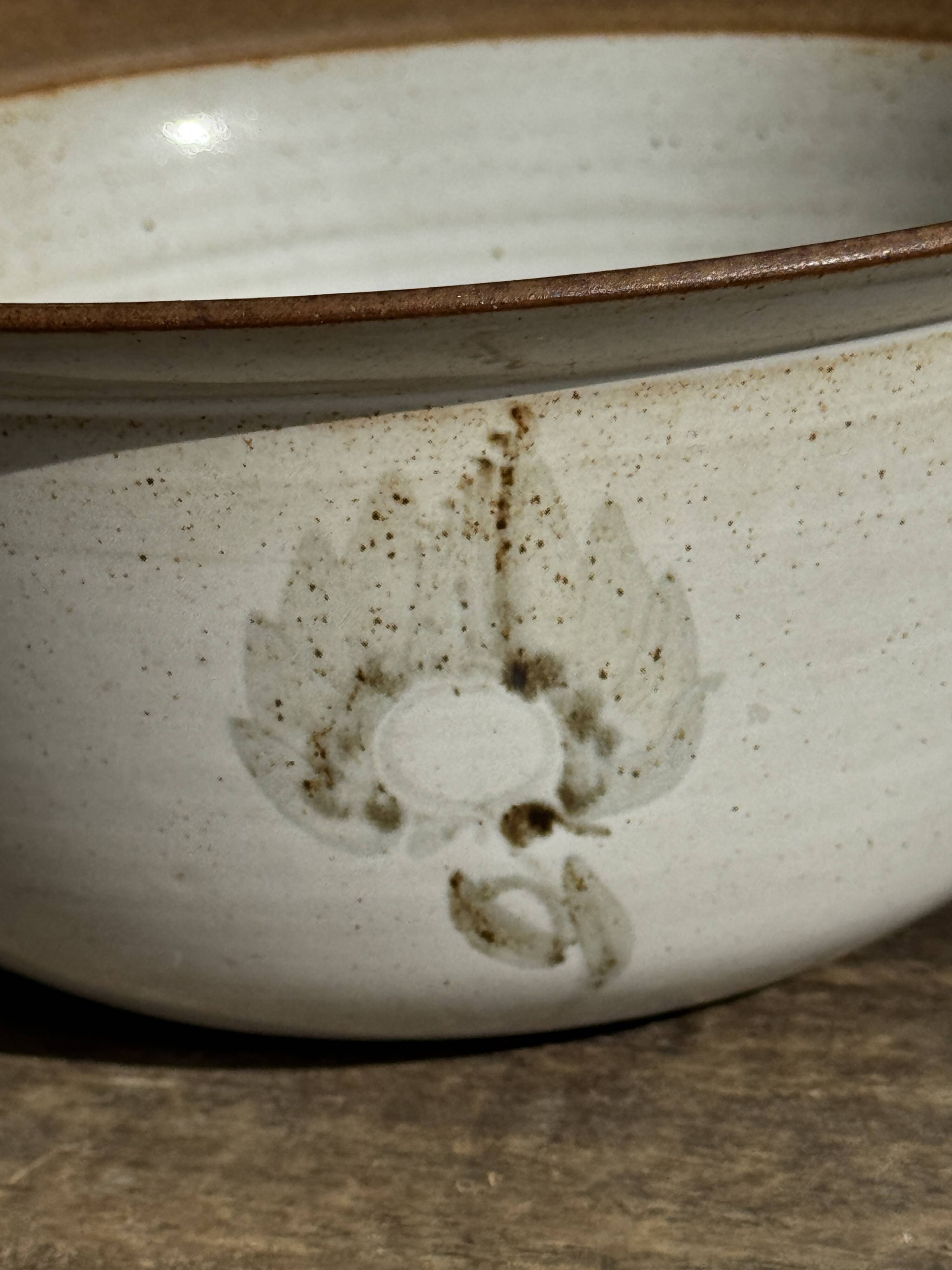 Small thick stoneware bowl with a stylised flower pattern in white on the outside, b