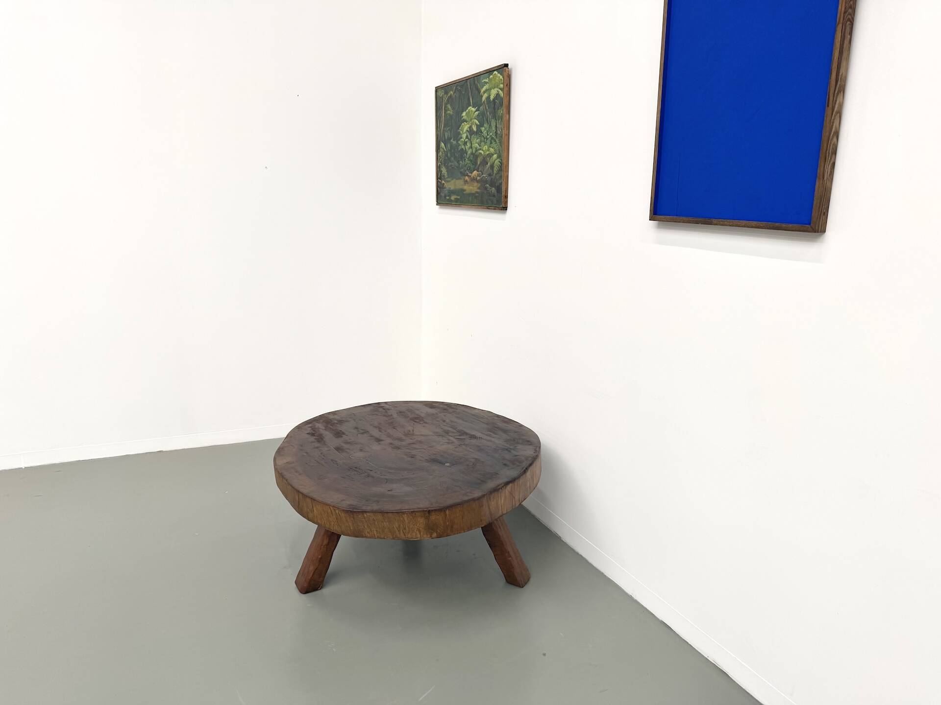 Brutalist coffee table in solid teak, monolithic slab, tripod base.