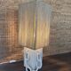 Table lamp in ceramic with decorative chain and cord shade.