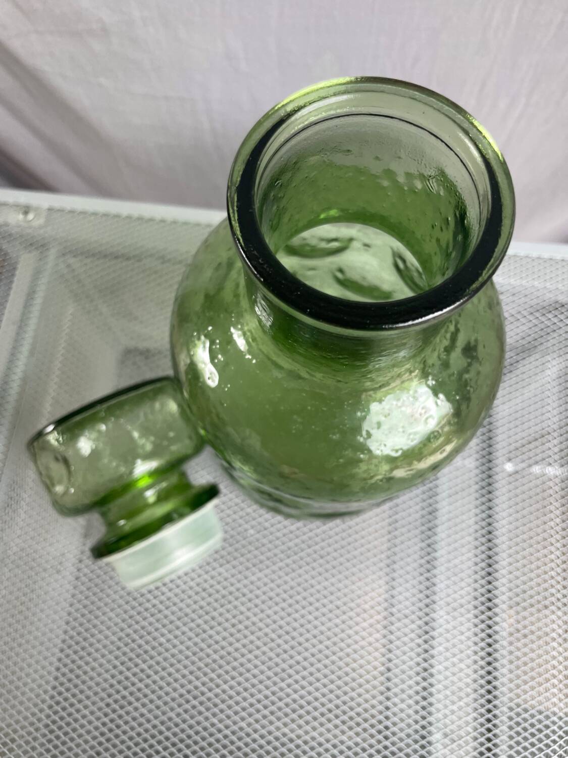 Green glass bottle with craters