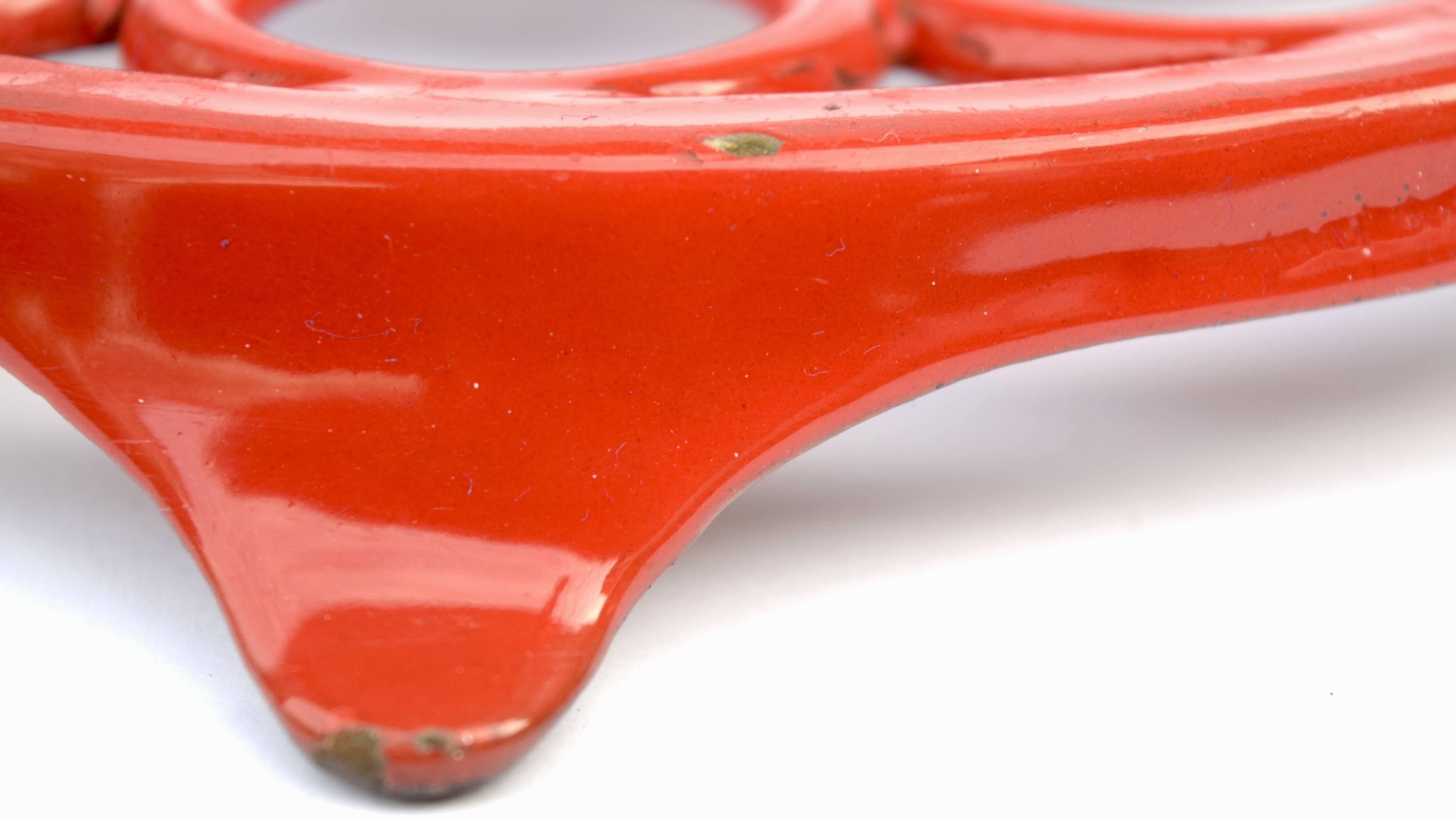 Vintage red enameled cast iron trivet