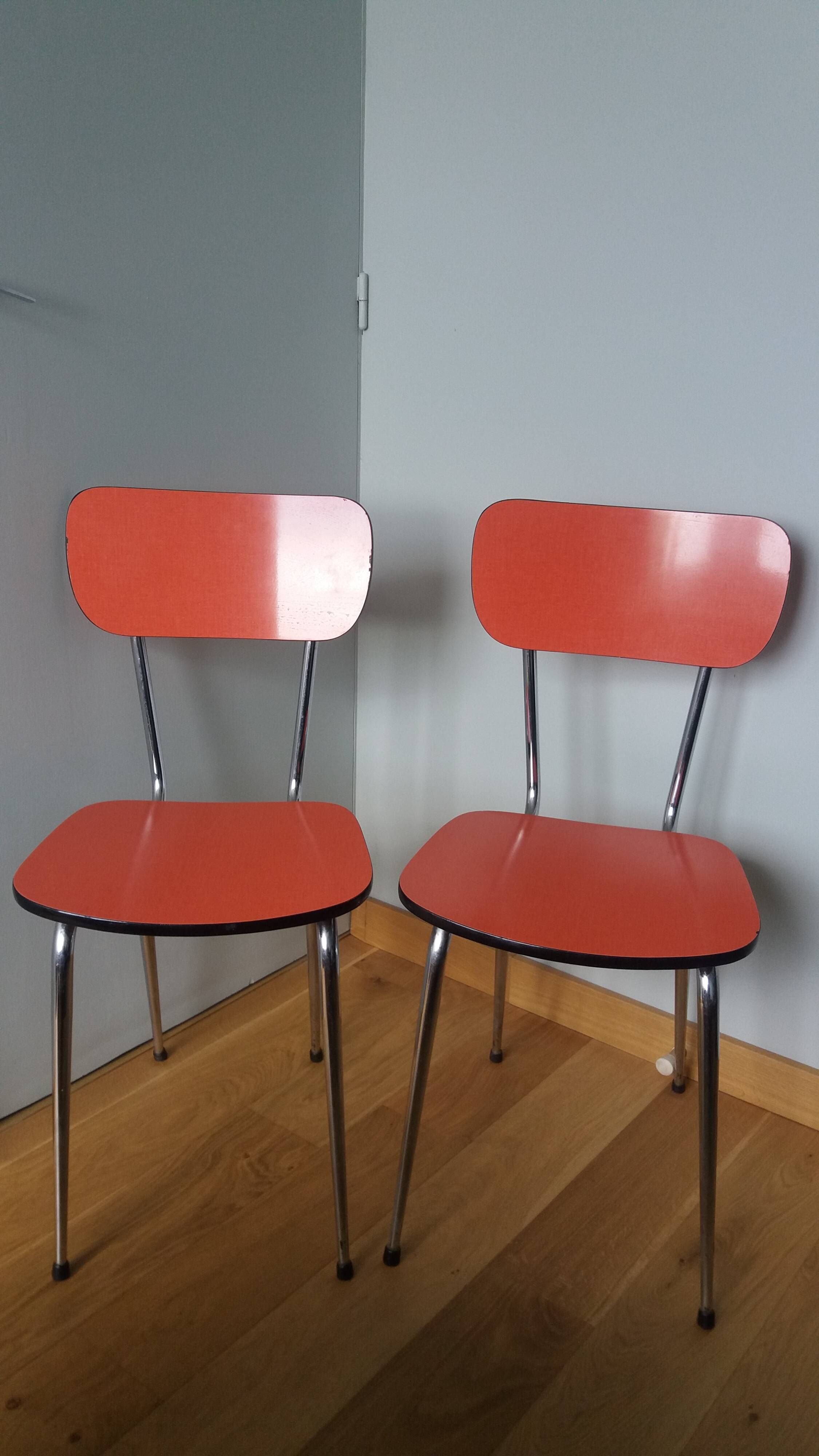 Chairs in red-orange formica and chrome metal.