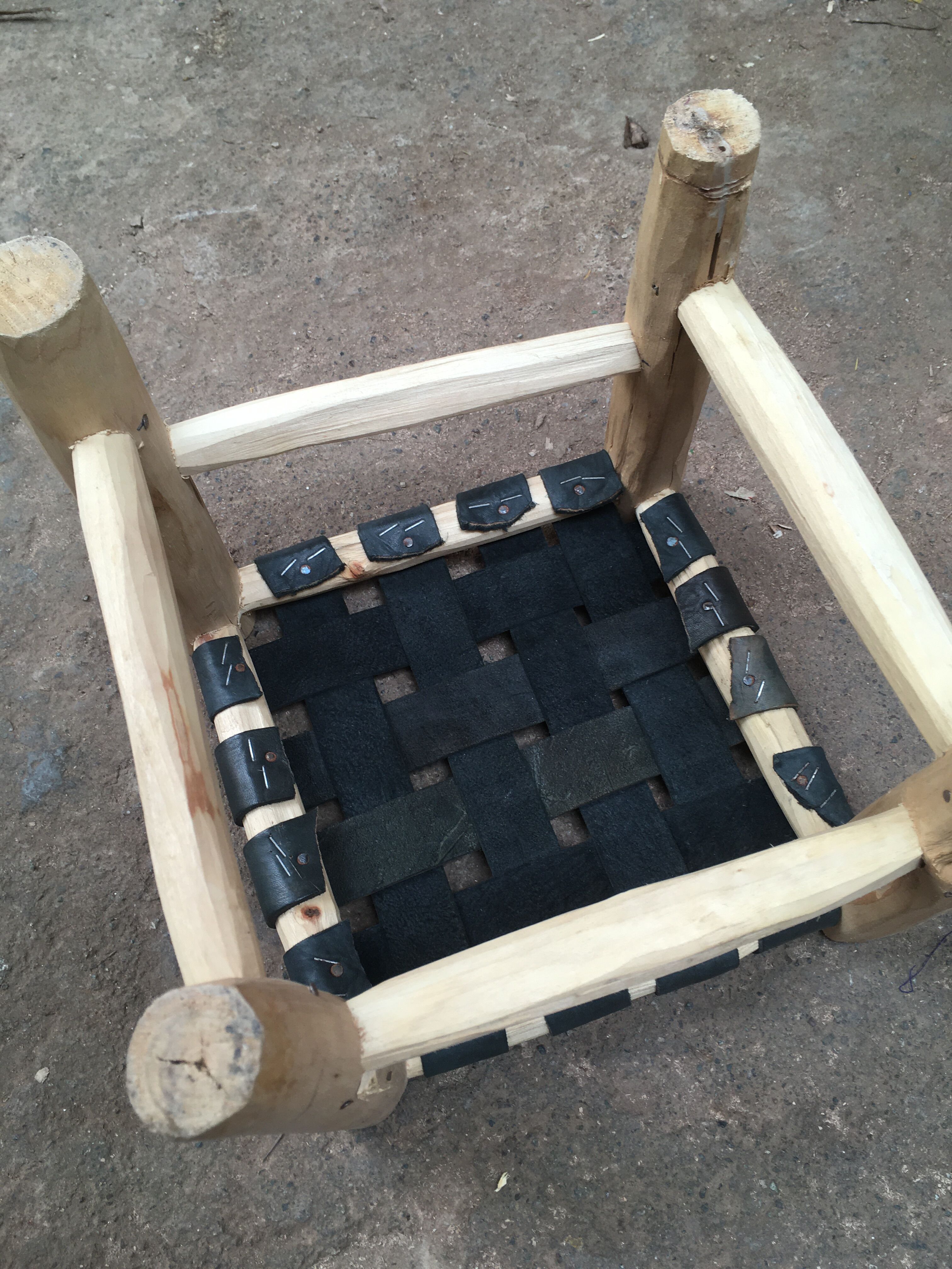 Traditional Moroccan stool in black leather and raw wood