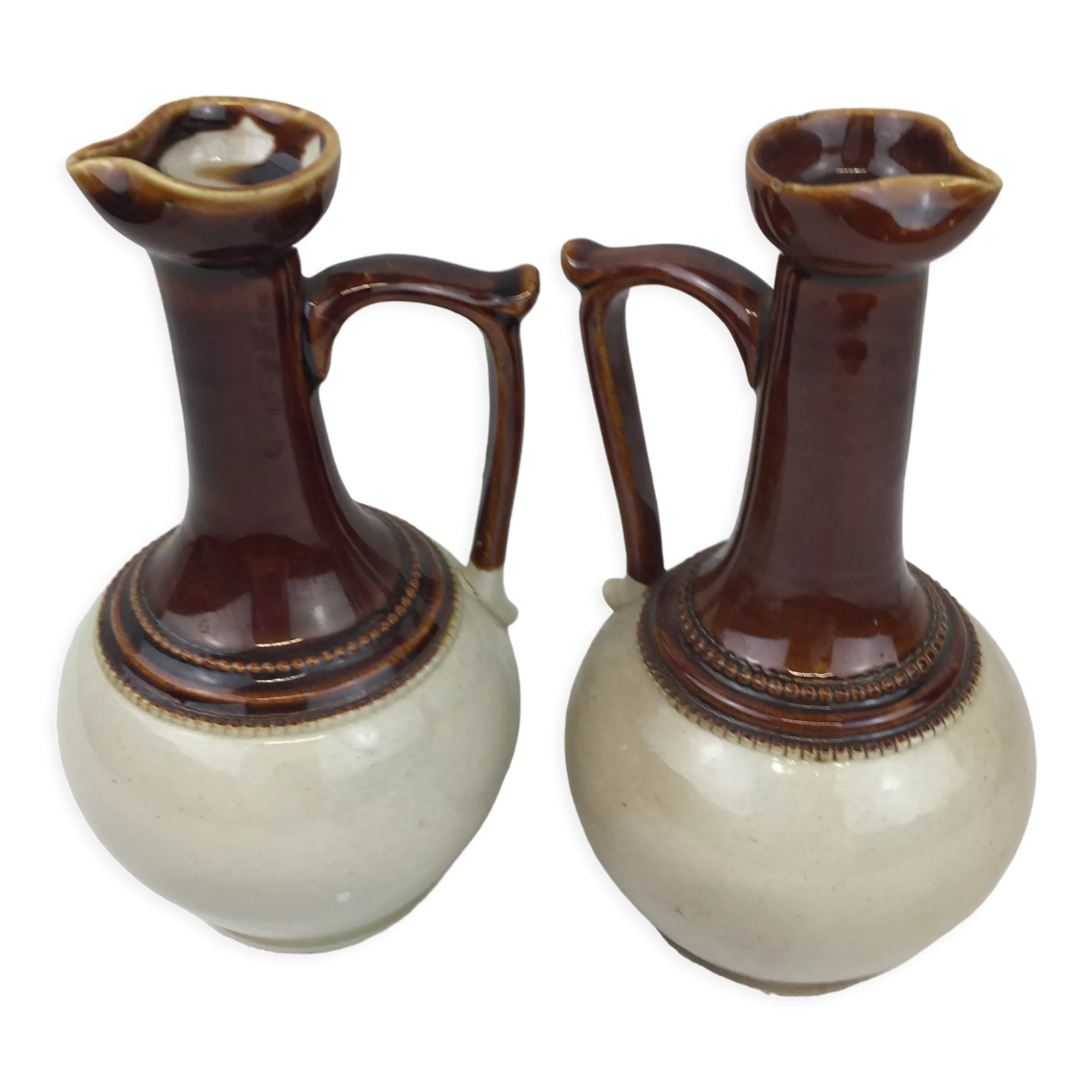 Antique handmade pitchers in beige and brown enamelled terracotta