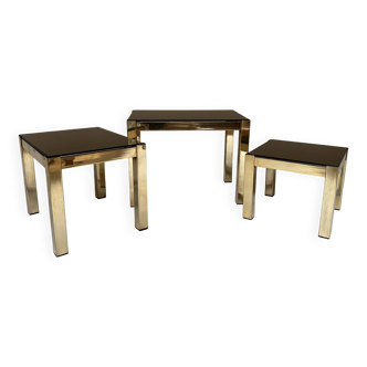 Set of three nesting side tables in brass and smoked mirror.