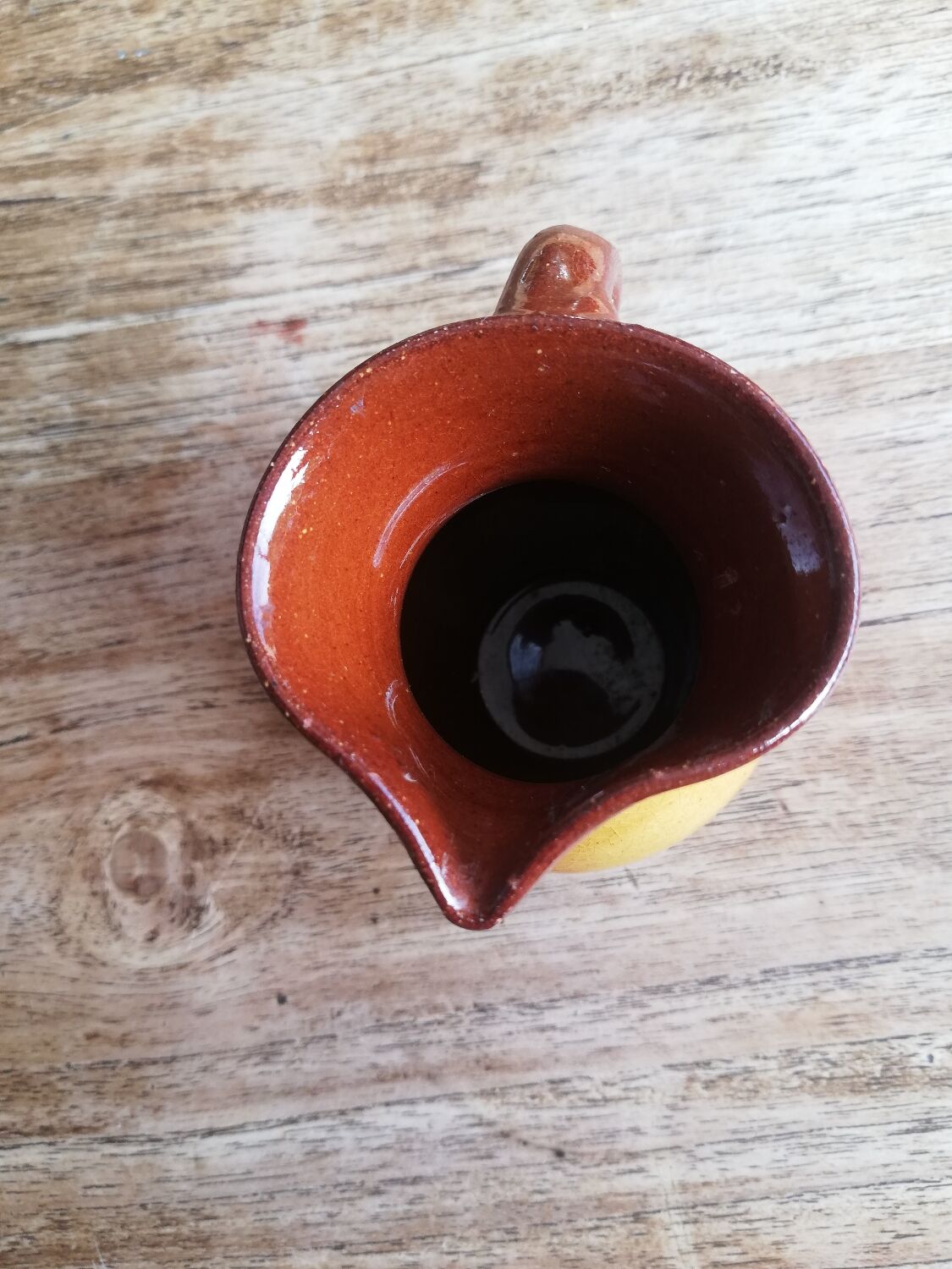 Small two-tone brown-yellow terracotta pitcher