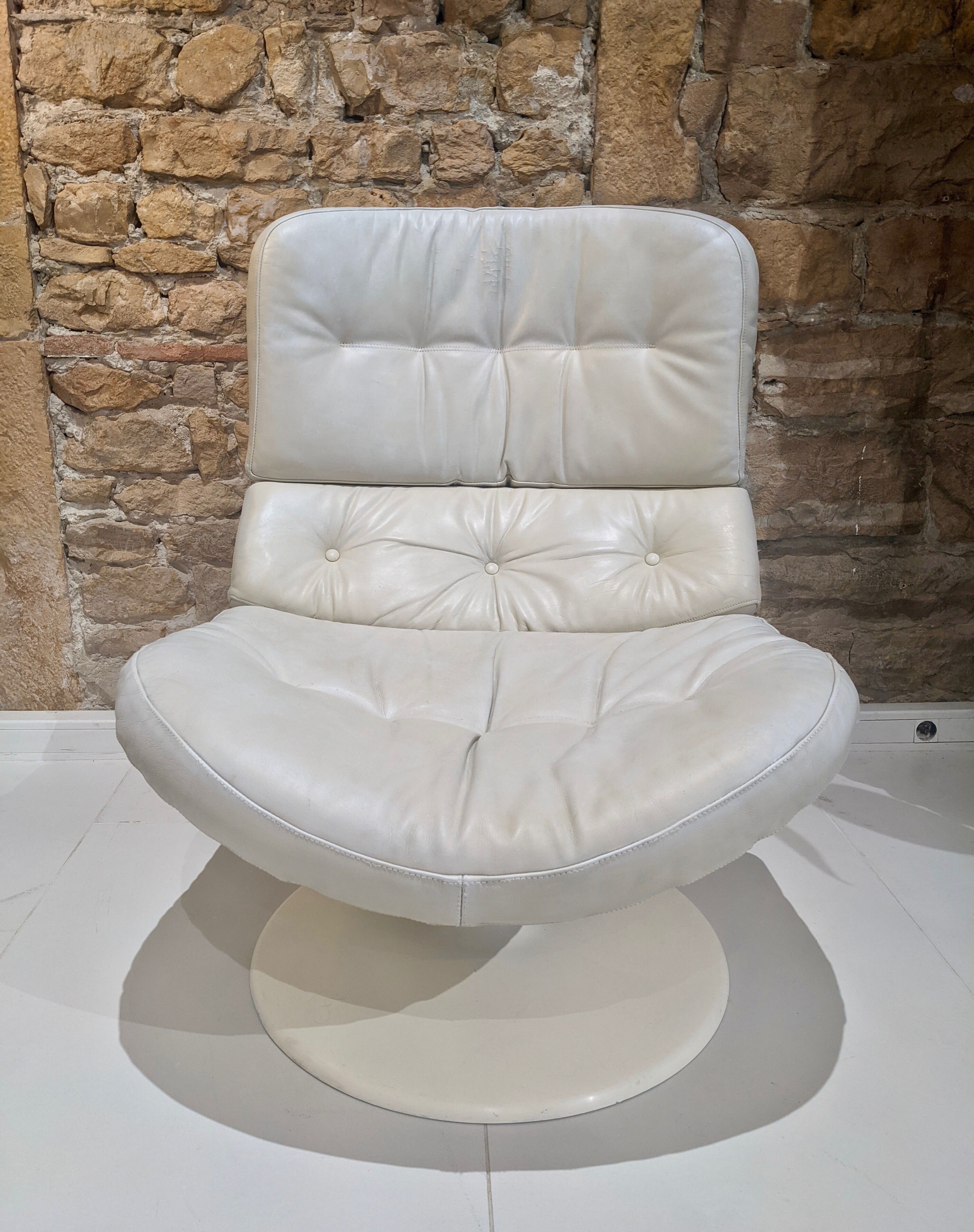 Swivel armchair in grey patinated leather