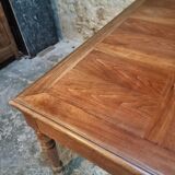 Antique French walnut table with six drawers, parquet top, early 20th century.