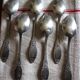 A set of 6 silver-plated metal soup spoons with foliage design.