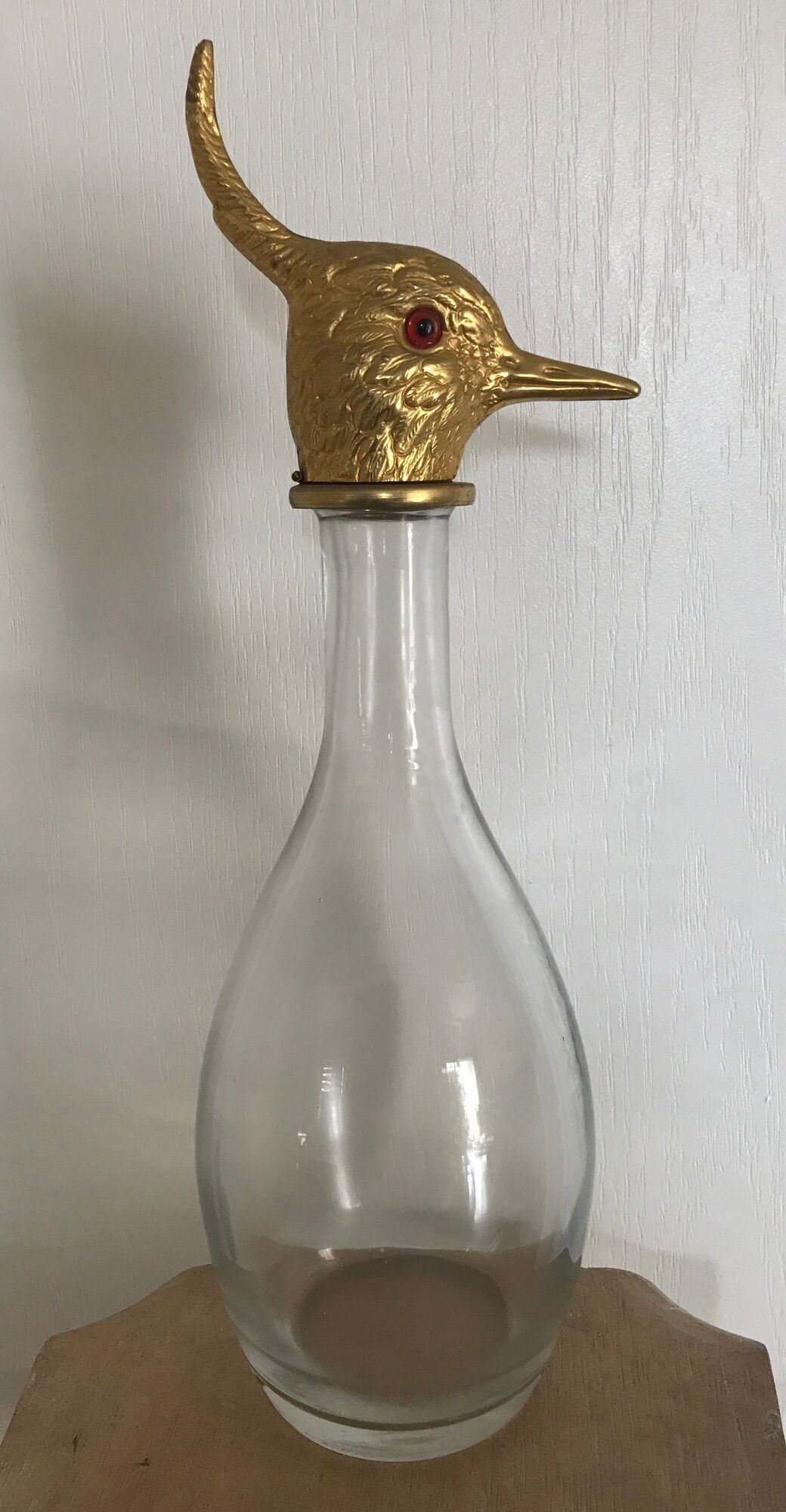 Glass bottle type carafe with gold metal bird head stopper