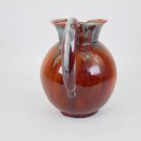 Large red and blue glazed ceramic pitcher signed Delène under the base