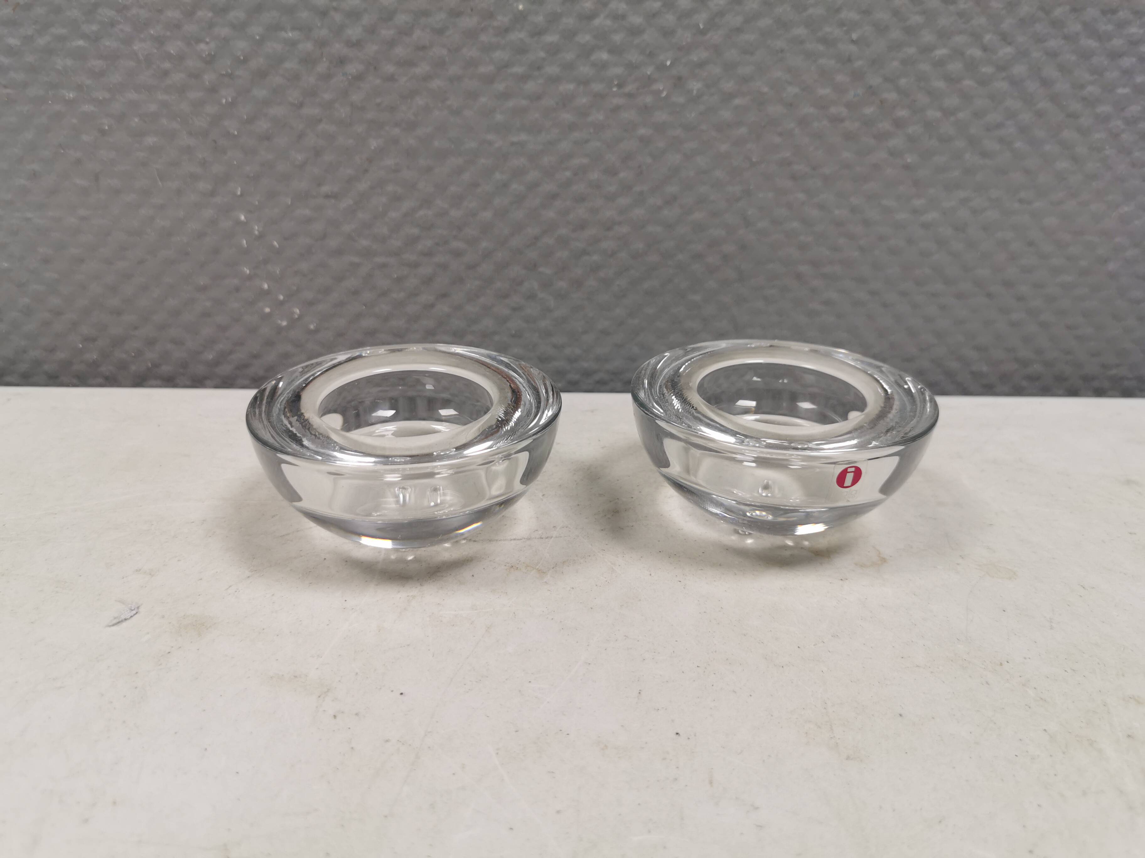 A set of iittala candle holders in clear transparent glass.