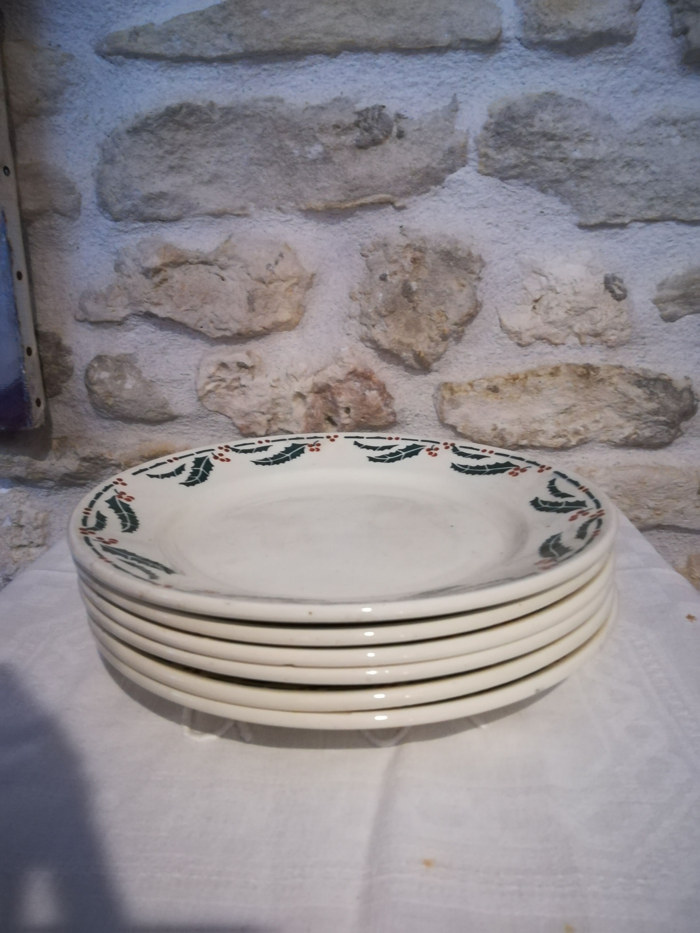 Six flat earthenware plates decorated with holly