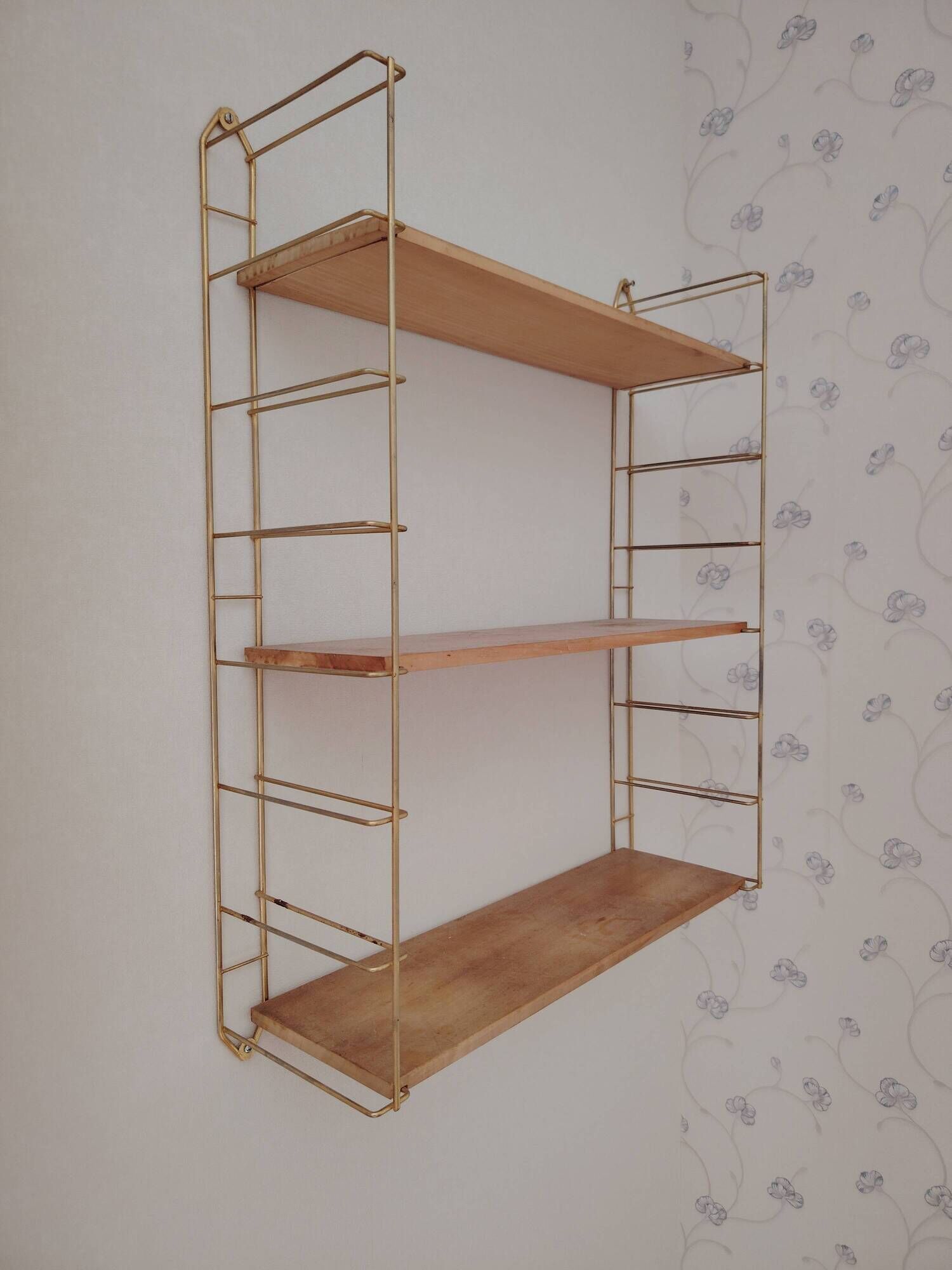 Vintage modular wall shelf in golden steel wire and wood from the 1950s.