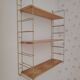 Vintage modular wall shelf in golden steel wire and wood from the 1950s.