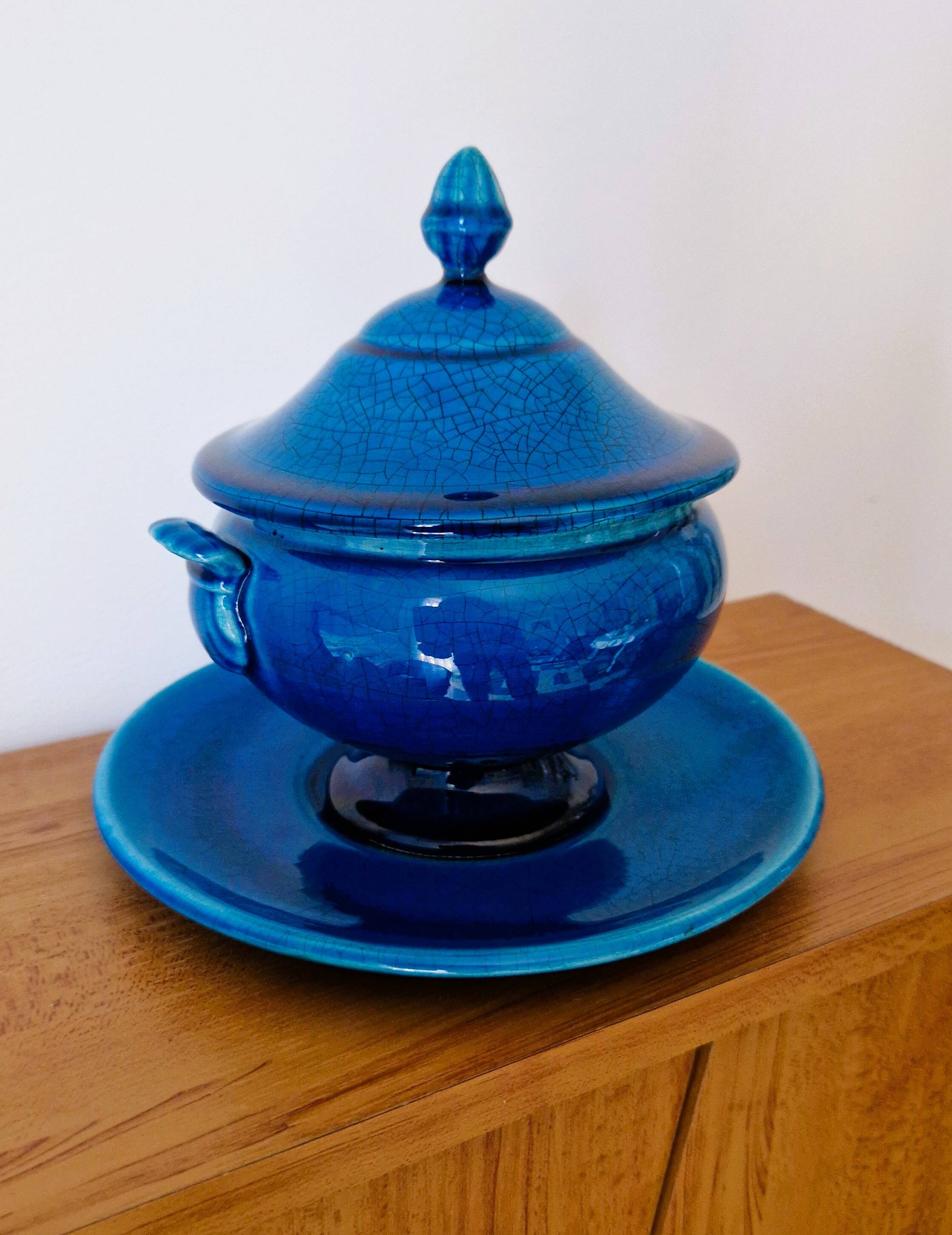 Blue ceramic soup tureen and crackled finish trivet.