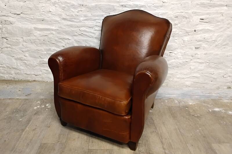 Antique club chair with gendarme hat back