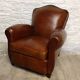 Antique club chair with gendarme hat back