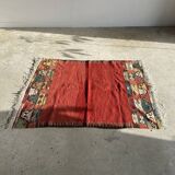 Small wool rug, predominantly red with geometric patterns