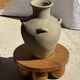 Light beige-grey Indonesian terracotta vase with 4 small handles and a high neck.