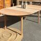 Large round family table with 2 extensions in solid raw wood.