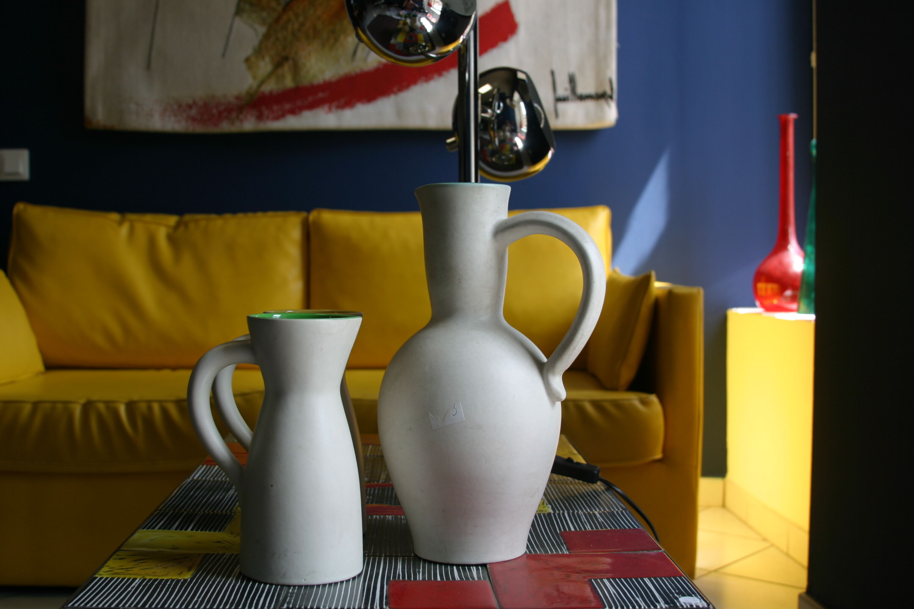 White ceramic pitcher with green background