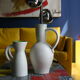White ceramic pitcher with green background