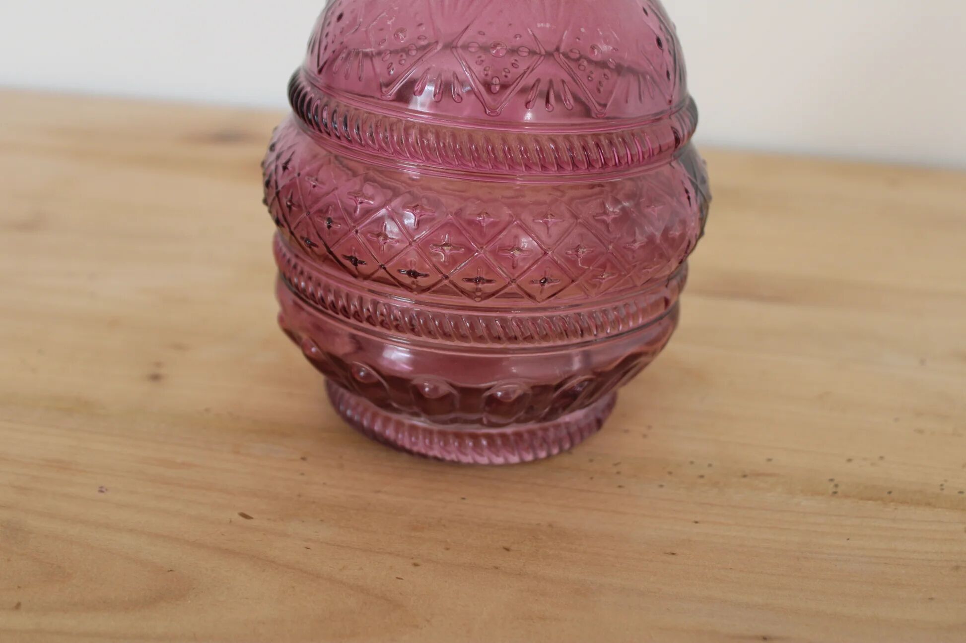 Vintage pink pressed glass carafe – retro decorative bottle with wooden stopper.