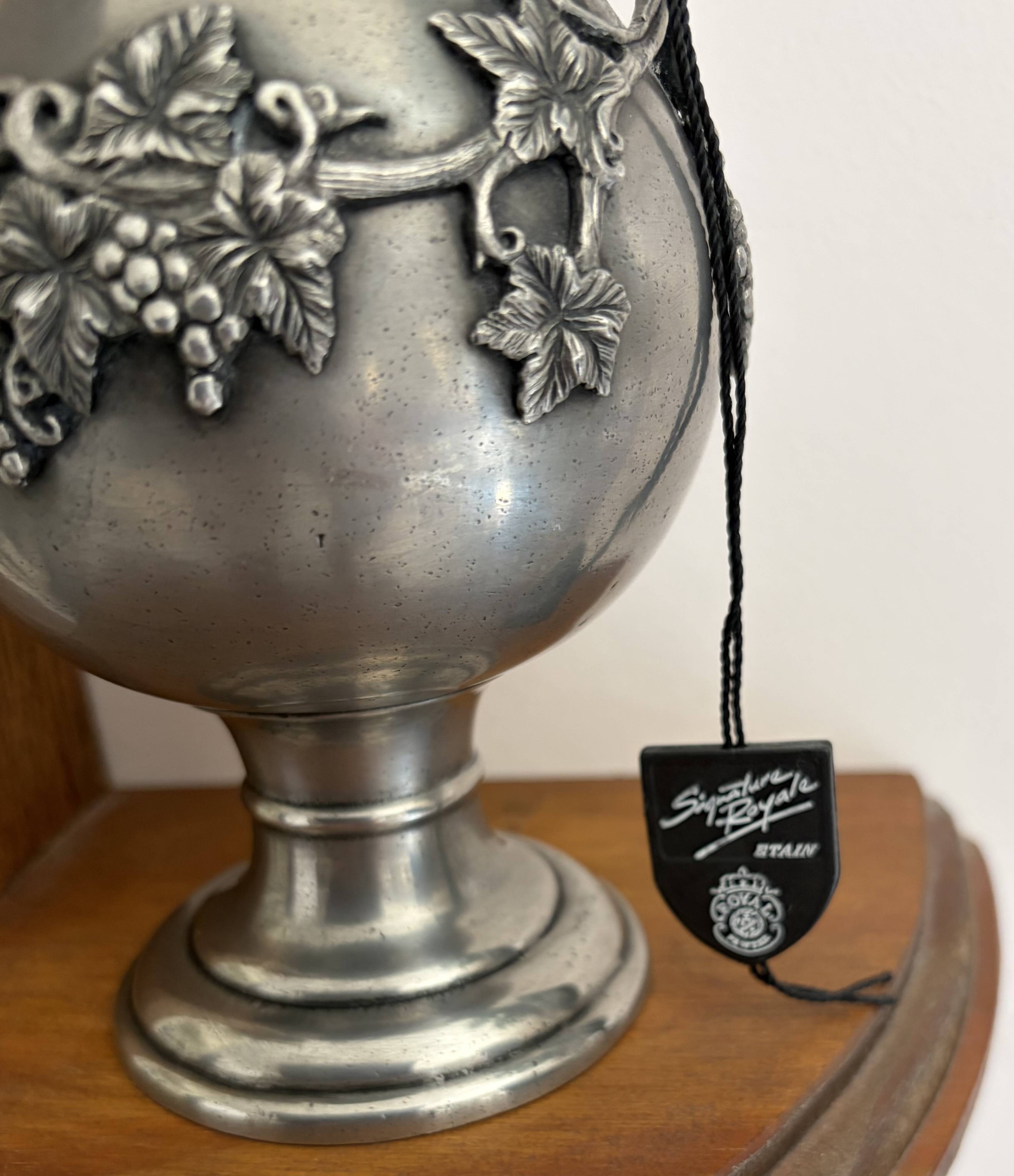 Ewer in pewter surrounded by vine branches with g