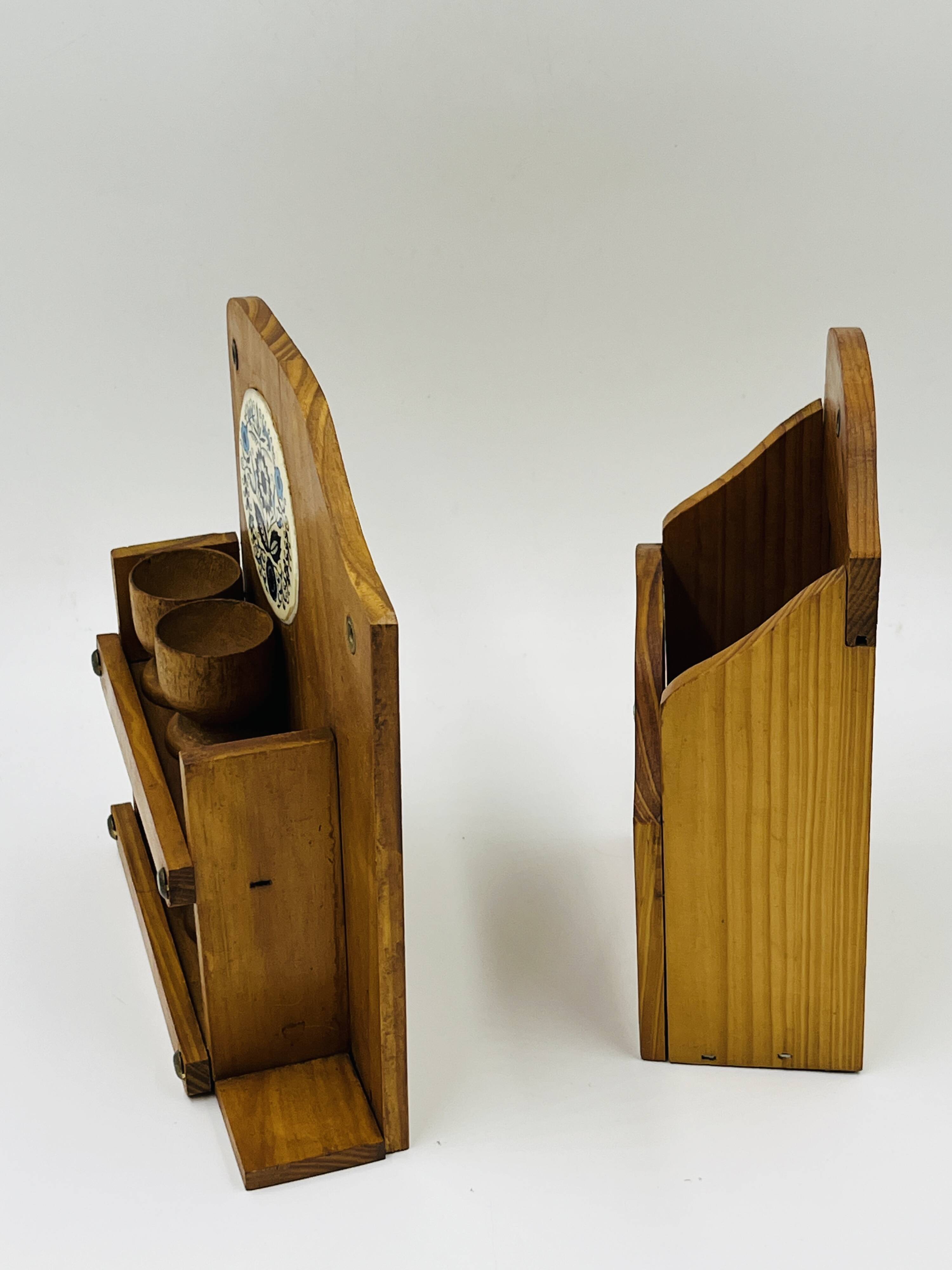 Wall-mounted egg cup holder and wooden utensil holder.