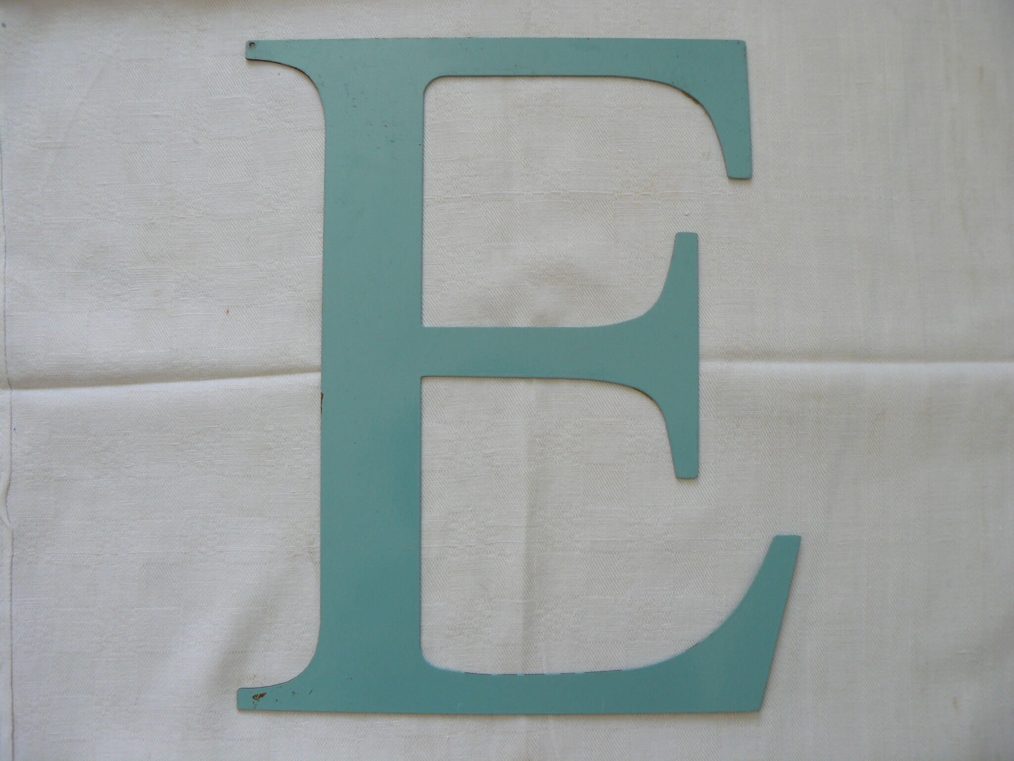 Old letter E painted metal sign