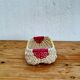 Vintage woven basket in yellow, white, and pink plastic.
