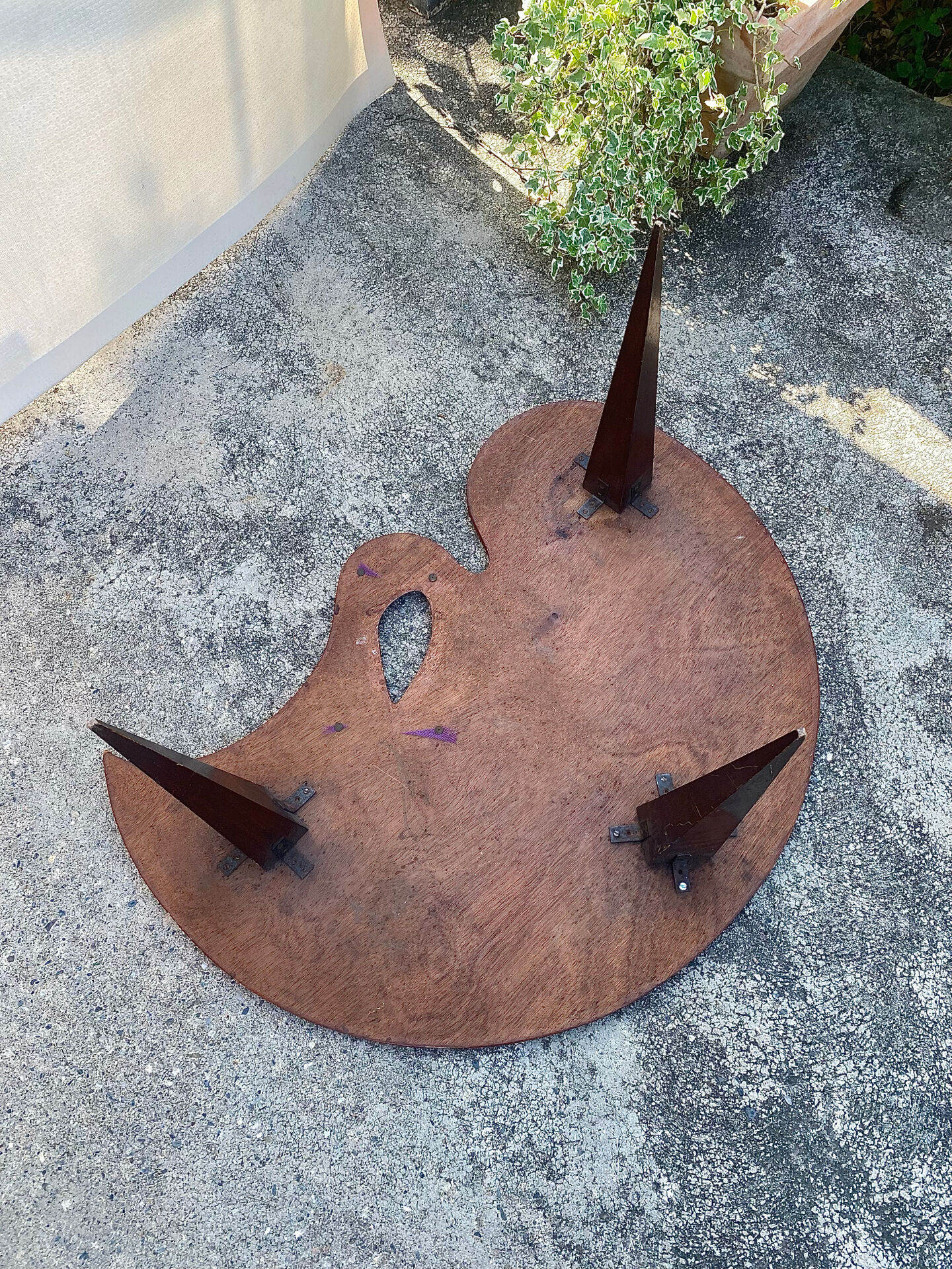 Mid-century coffee table with a palette shape and splayed legs.