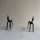 Pair of animal-shaped wrought iron and hammered fire dogs in primitive brutalist style.