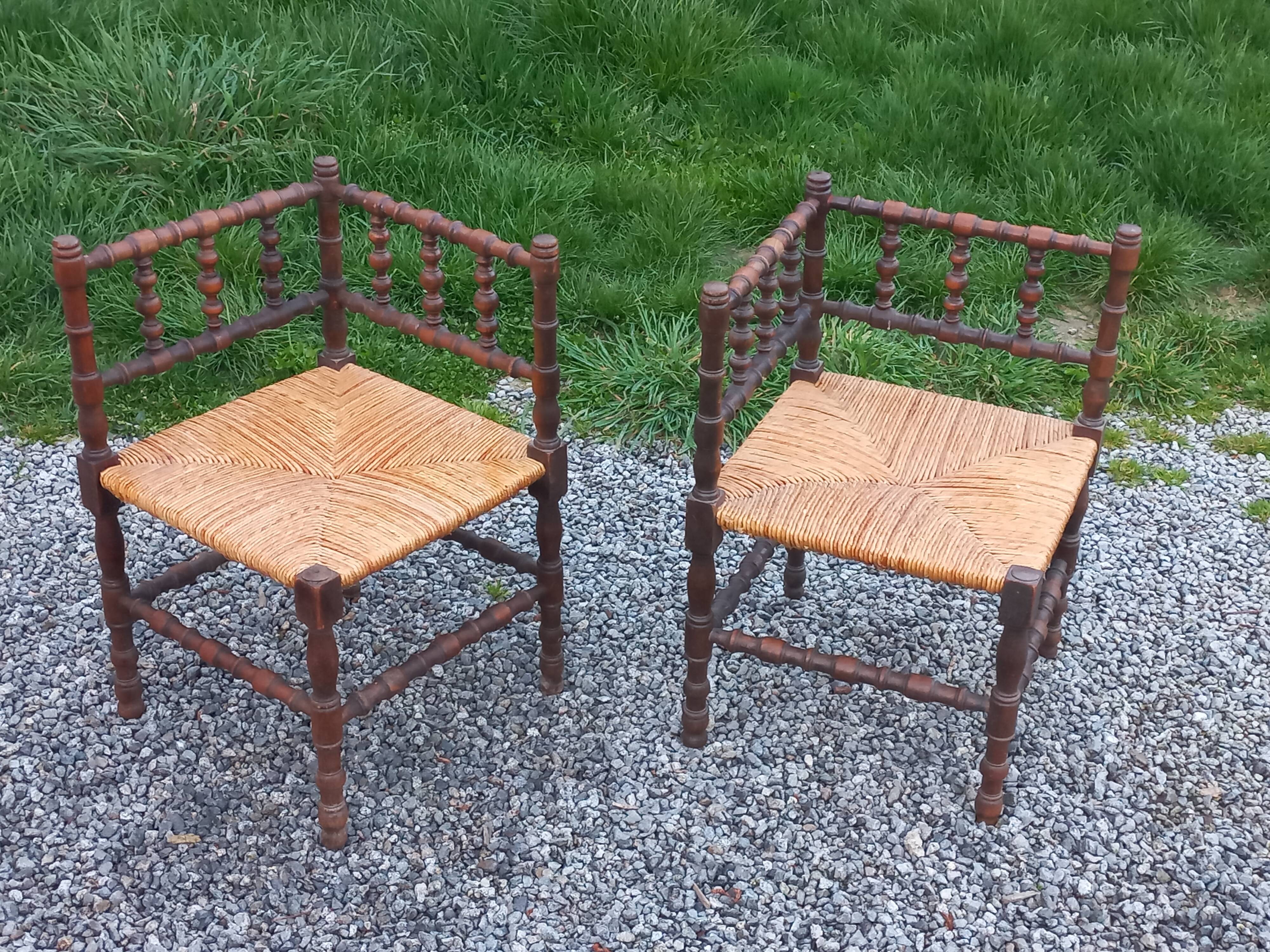 Pair of angled armchairs with turned wood and rush seats from the 1960s.