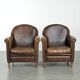 Characterful set of two sheepskin design armchairs with beautiful patina