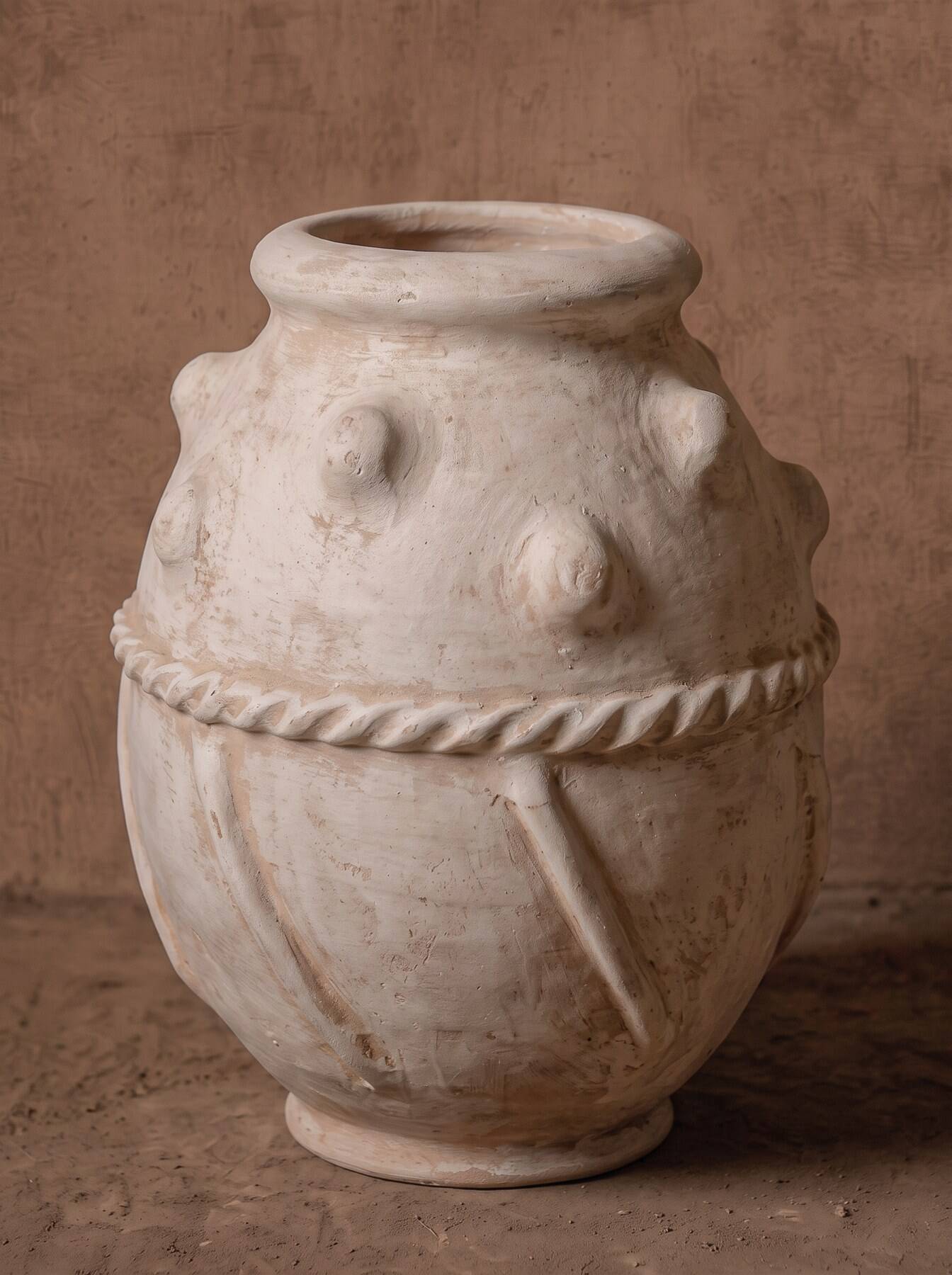 Glazed terracotta urn with protrusions and cordons.