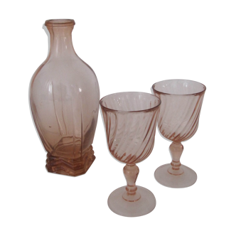 Old bottle in pink glass and 2 wine glasses