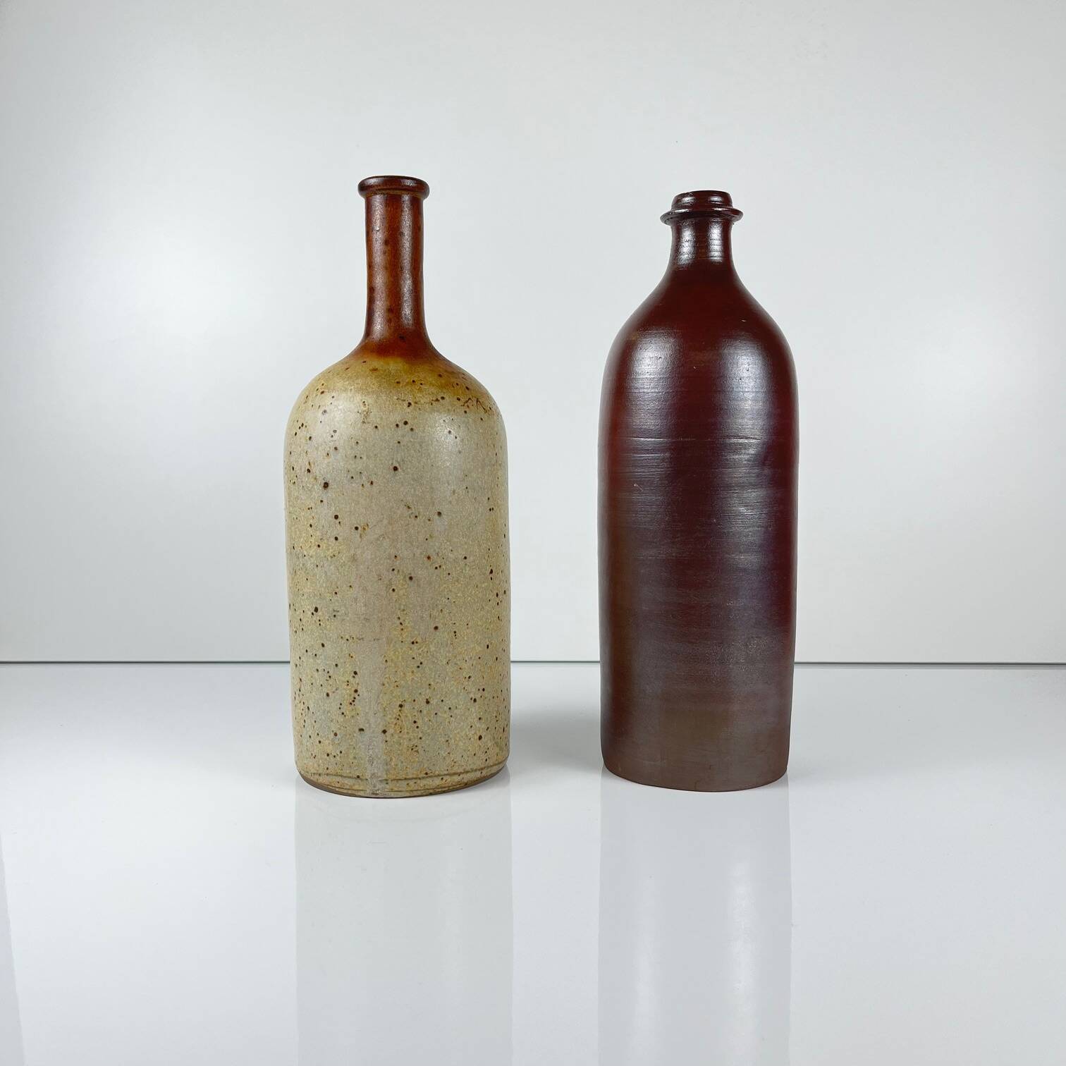 Duo of speckled stoneware and burgundy bottles, 20th century