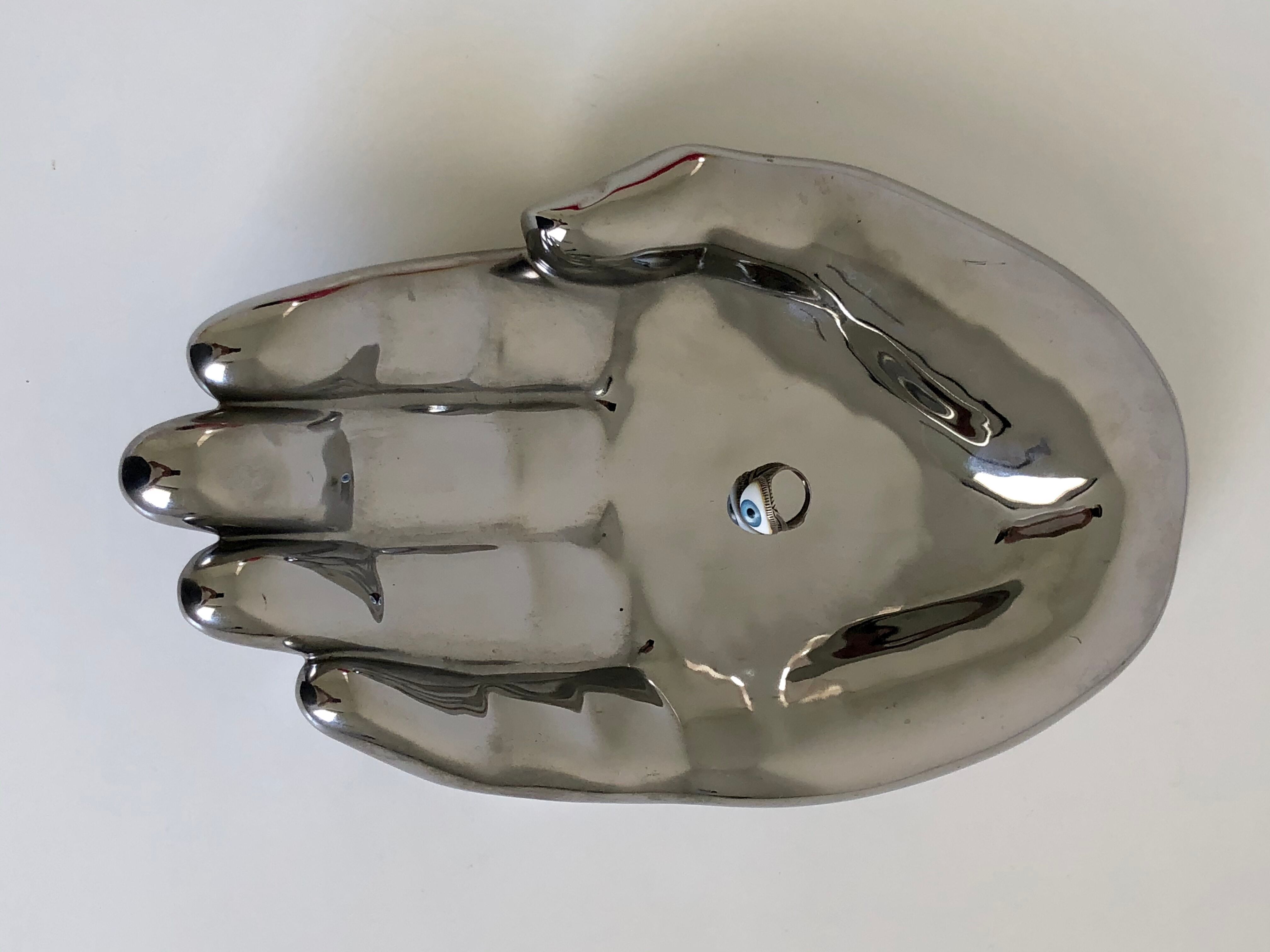Empty silver chromed ceramic pocket in the shape of a large hand, 1980