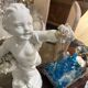 Child statue with flowers in porcelain, signed.