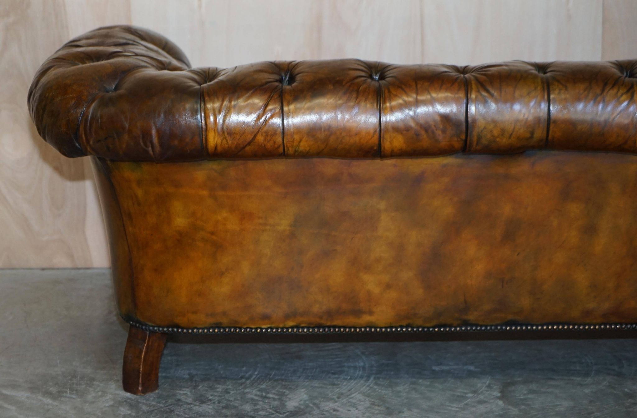 Victorian Chesterfield leather upholstered canapé with feather cushions.
