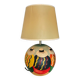 Ceramic table lamp representing women in hats on the sand.